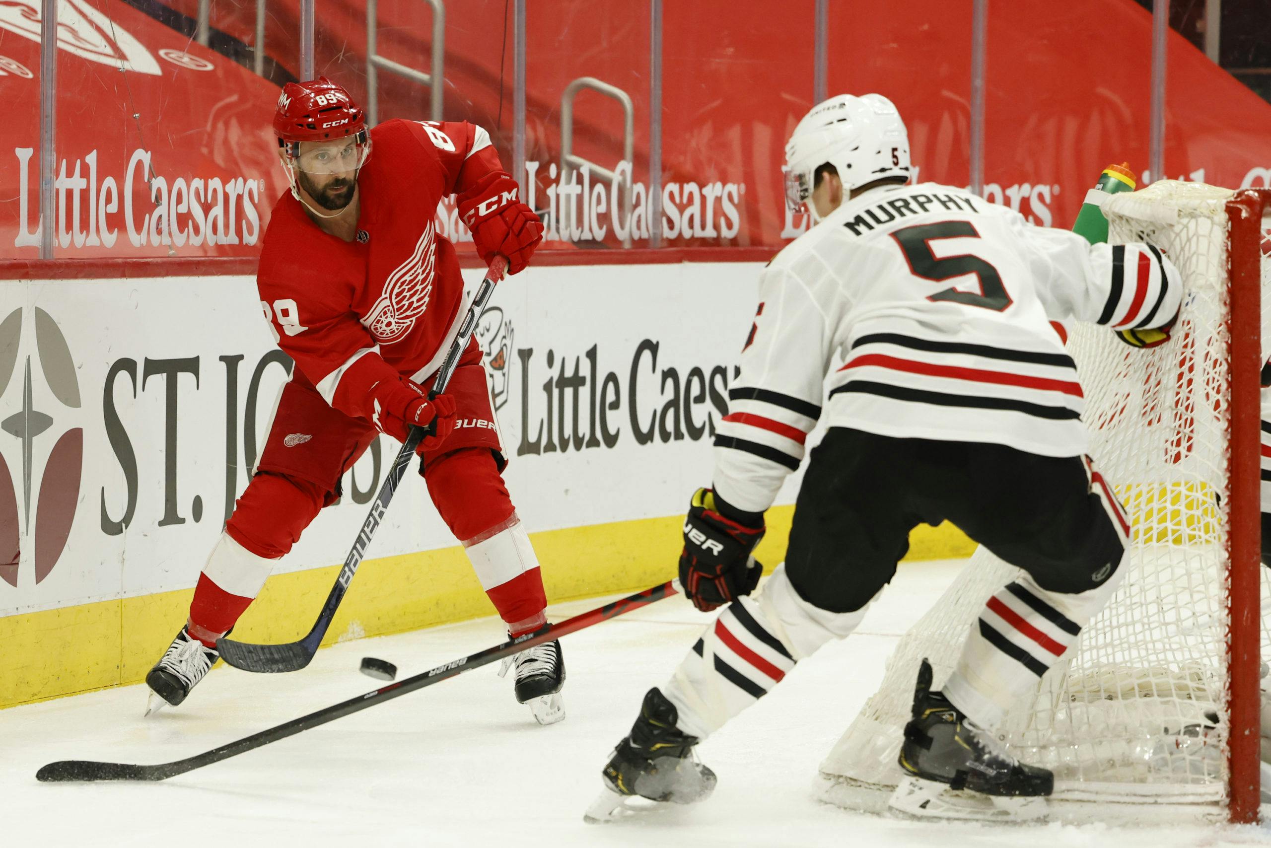 Detroit Red Wings center Sam Gagner (89) skates with the puck defended by Chicago Blackhawks defenseman Connor Murphy (5) in the second period at Little Caesars Arena.